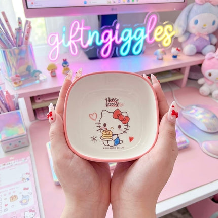Two light-coloured Hello Kitty bowls with pink rims held side by side showing the inside character design