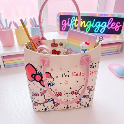 Hello Kitty tote bag held by its pink handles with a longer pink strap visible