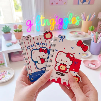 Hello Kitty apple print spiral diary and blue floral diary held in hand