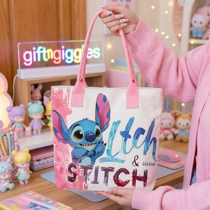 Open-top Stitch character tote bag with pink handles shown beside stationery props